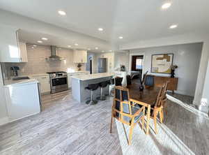 Dining area with light wood finished floors and recessed lighting