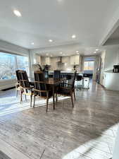 Dining space with light wood-style floors and recessed lighting