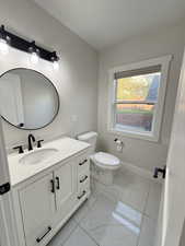 Bathroom featuring vanity and light marble finish floors