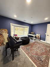 Living area featuring carpet and baseboards
