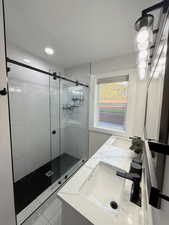 Full bathroom featuring double vanity and a shower stall