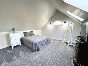 Carpeted bedroom featuring a skylight and baseboards