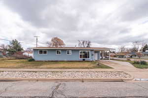 Ranch-style house featuring driveway and an attached carport
