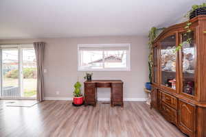 Office space featuring light wood-style floors and a textured ceiling