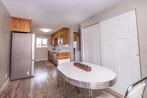 Dining space featuring dark wood-type flooring and a textured ceiling