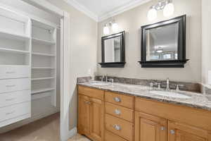 Primary bathroom with double vanity and walk-in closet