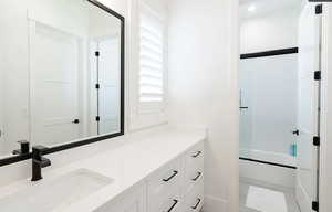 Bathroom with vanity and shower / bath combination with glass door