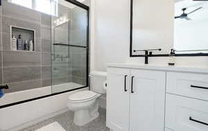 Bathroom featuring vanity, combined bath / shower with glass door, ceiling fan, and tile patterned flooring