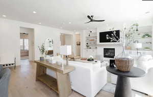 Living area featuring ceiling fan, light wood-type flooring, built in shelves, a fireplace, and recessed lighting