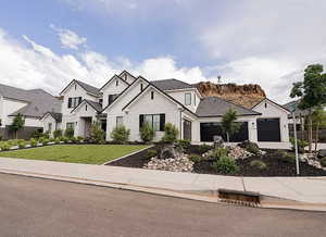 View of front of home featuring stone siding, an attached garage, a front yard, and concrete driveway