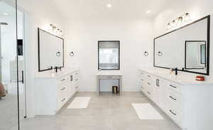 Full bathroom featuring two vanities and recessed lighting