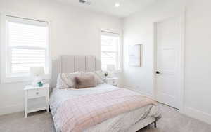 Bedroom with light carpet and recessed lighting