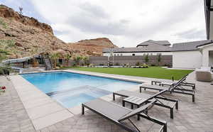 Relaxing pool / spa with a patio, a fenced backyard, and a mountain view