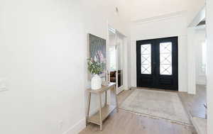 Foyer with light wood finished floors and french doors
