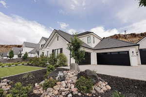View of front of property featuring stucco siding, driveway, a tiled roof, a garage, and a front yard