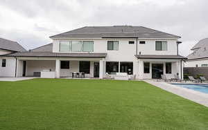 Rear view of house with a patio, a tiled roof, and stucco siding