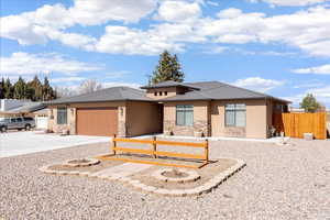 Prairie-style home with a garage, driveway, stone siding, stucco siding, and a metal roof