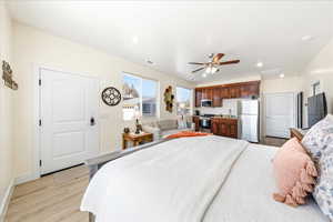 Bedroom featuring light wood-type flooring, freestanding refrigerator, ceiling fan, and recessed lighting