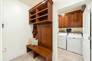 Laundry room featuring cabinet space, independent washer and dryer, and light floors