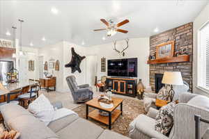 Living area featuring ceiling fan and a fireplace