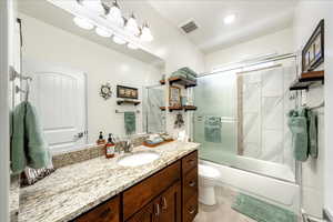 Bathroom featuring vanity and combined bath / shower with glass door
