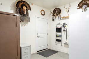 Foyer entrance with baseboards and concrete flooring