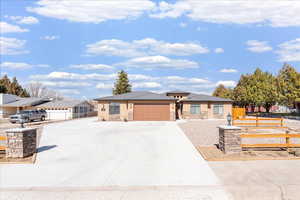 Prairie-style house featuring concrete driveway, stone siding, and a garage