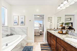 Full bathroom with double vanity, a garden tub, connected bathroom, and ceiling fan