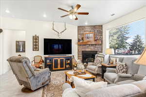 Living room with ceiling fan, a fireplace, and recessed lighting