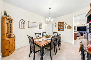 Dining area featuring a chandelier and baseboards