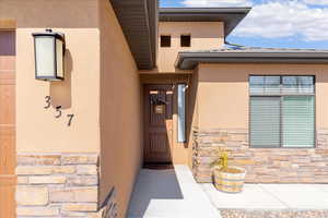 Doorway to property with stone siding and stucco siding