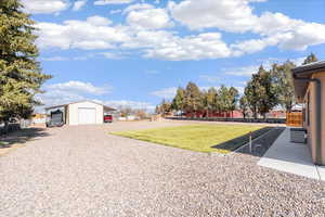 View of yard with an outbuilding, a garage, and driveway