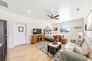 Bedroom featuring freestanding refrigerator, light wood finished floors, ceiling fan, and recessed lighting