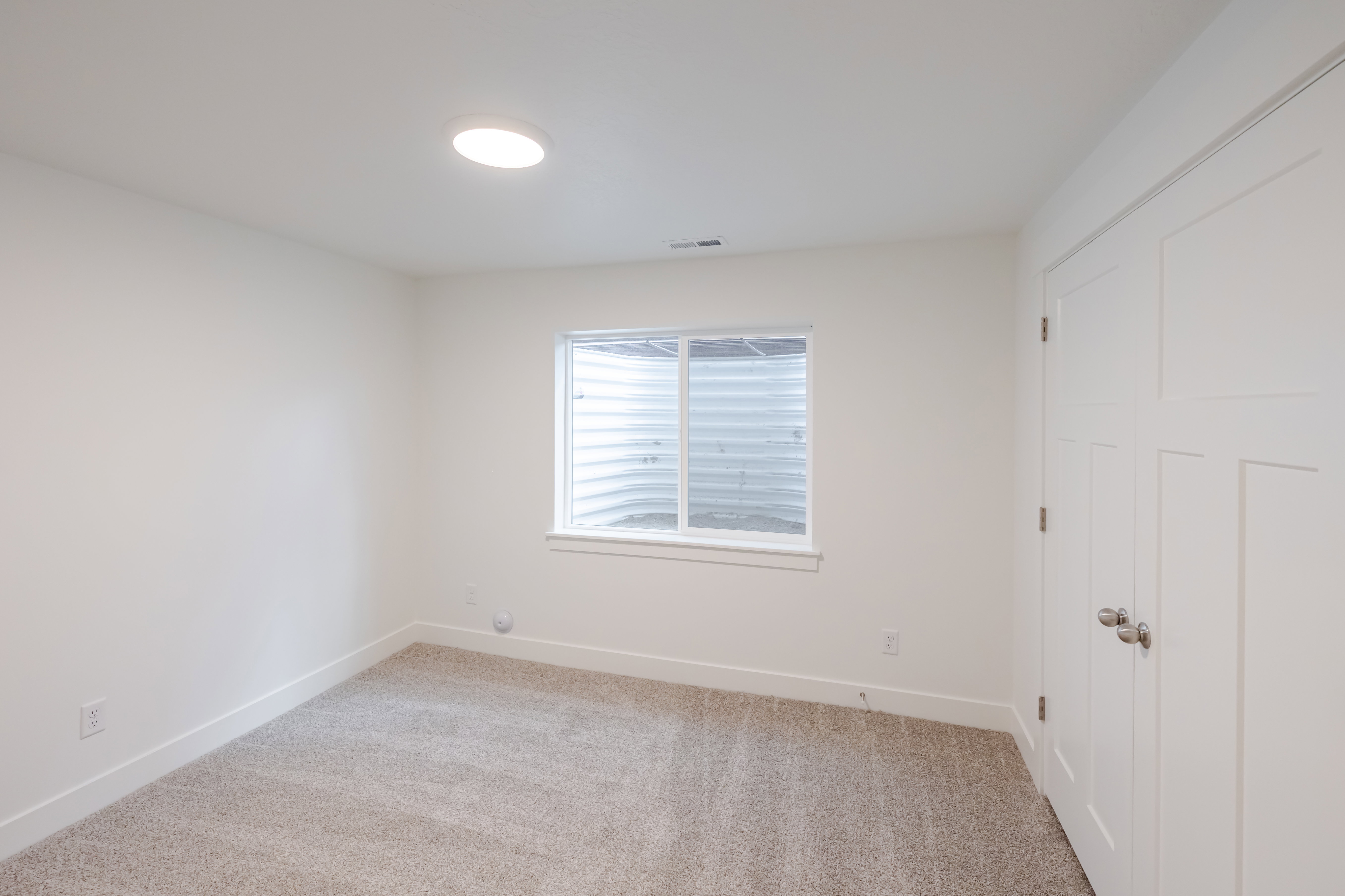 Room featuring light-colored carpeting and white walls