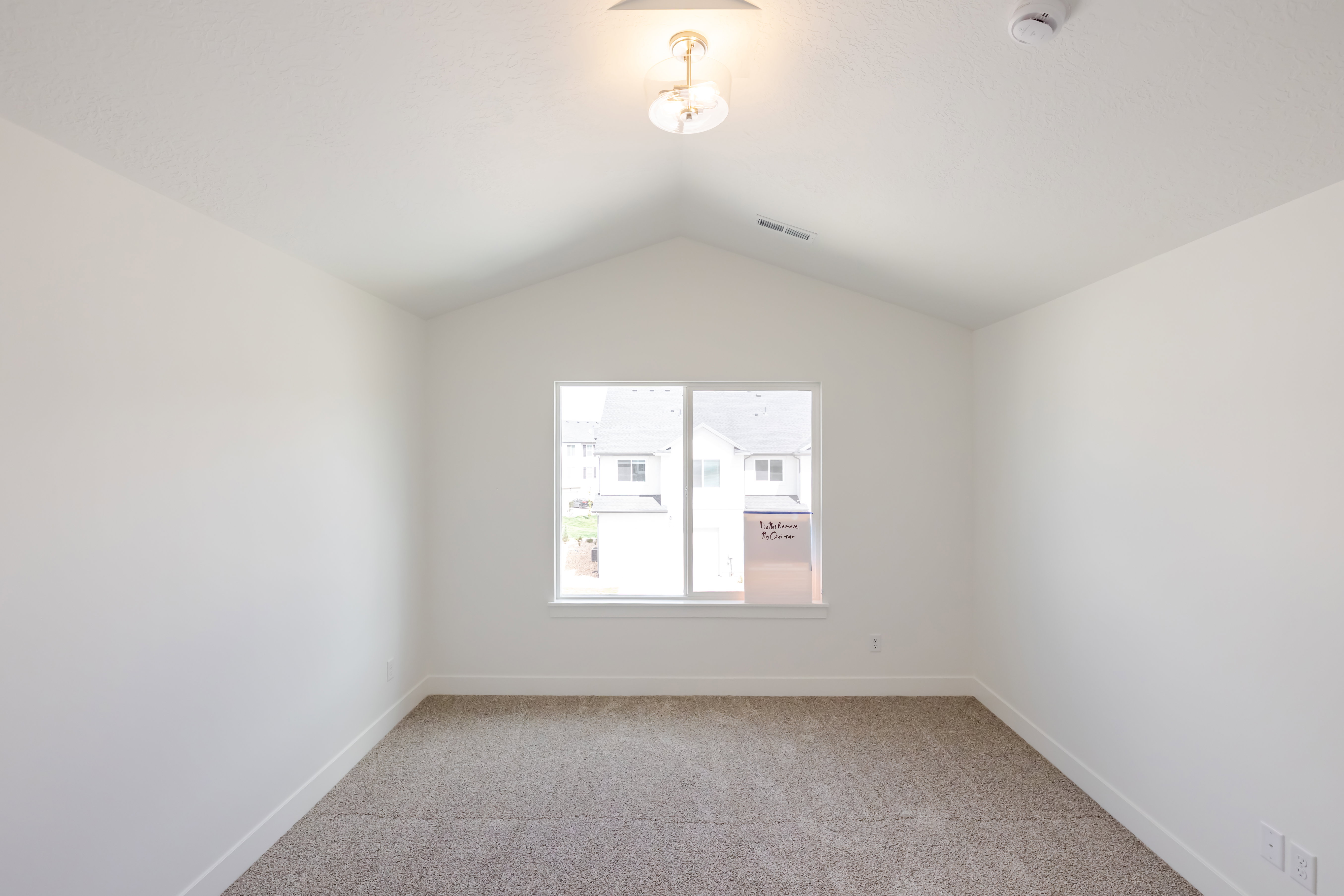 Room featuring vaulted ceilings, neutral-toned carpeting, white baseboards, and a double-paned window