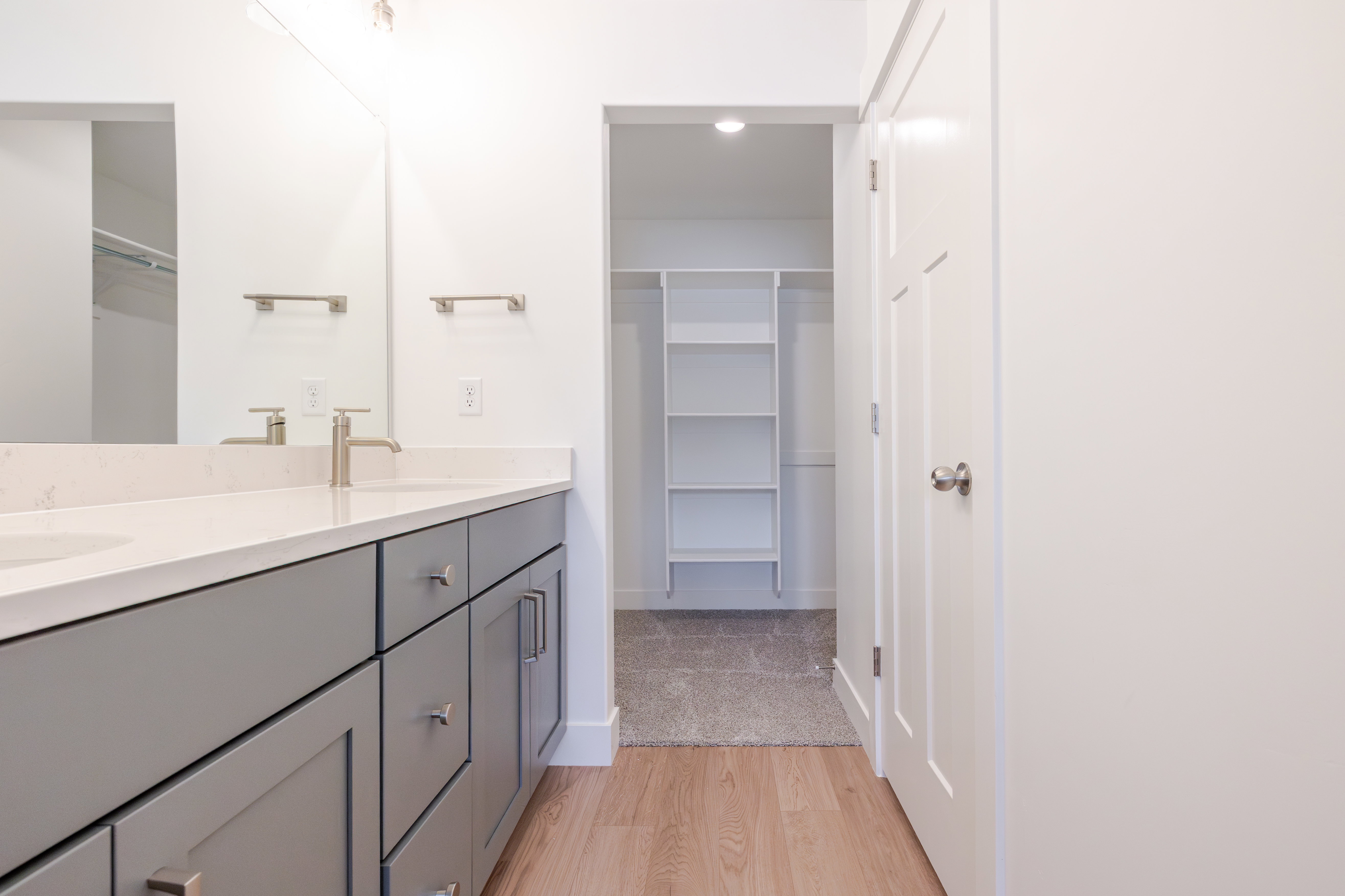 Double vanity with gray cabinetry, brushed nickel hardware, and light-toned countertops