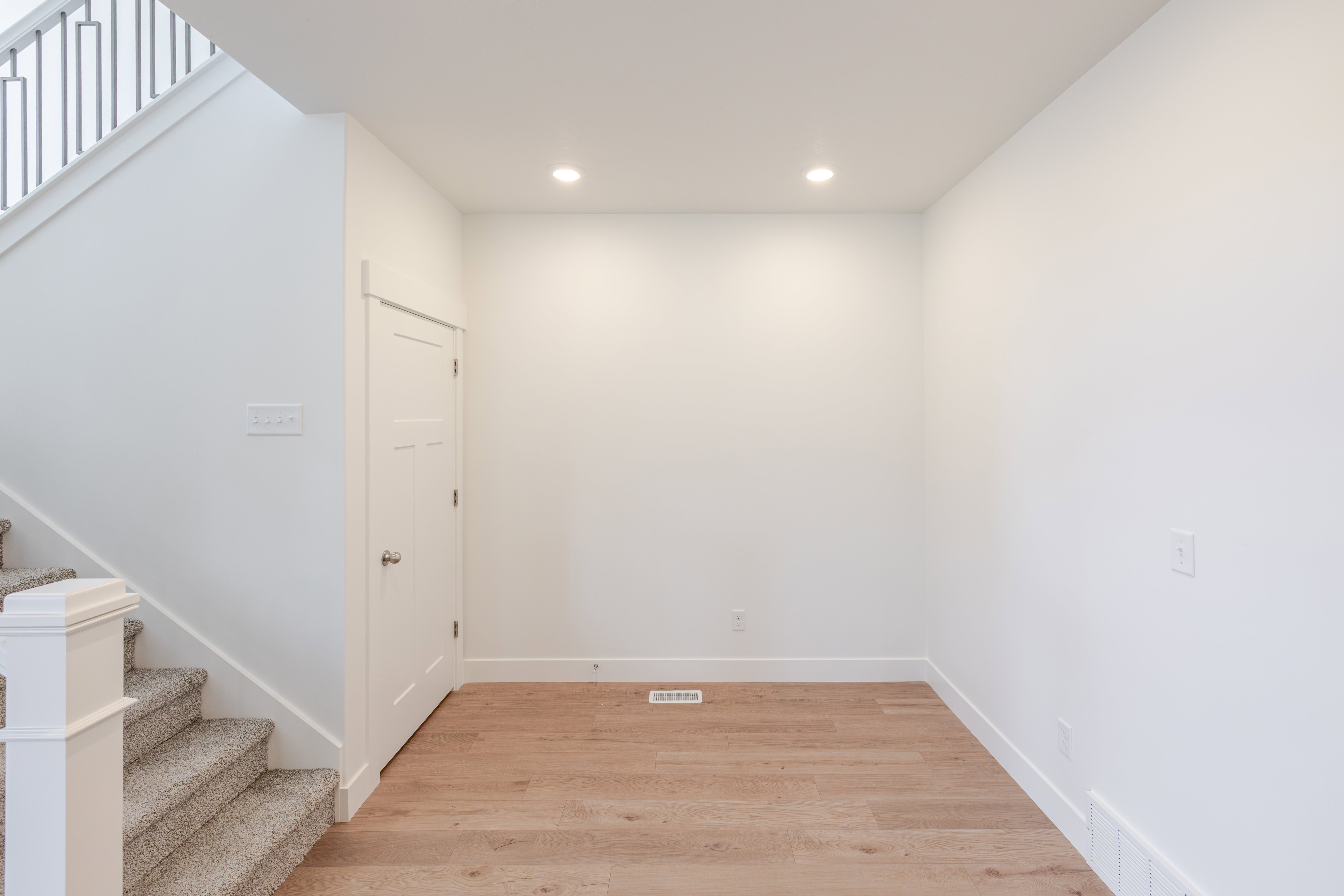 Bright interior space featuring wood-finish flooring, recessed ceiling lighting, and crisp white walls