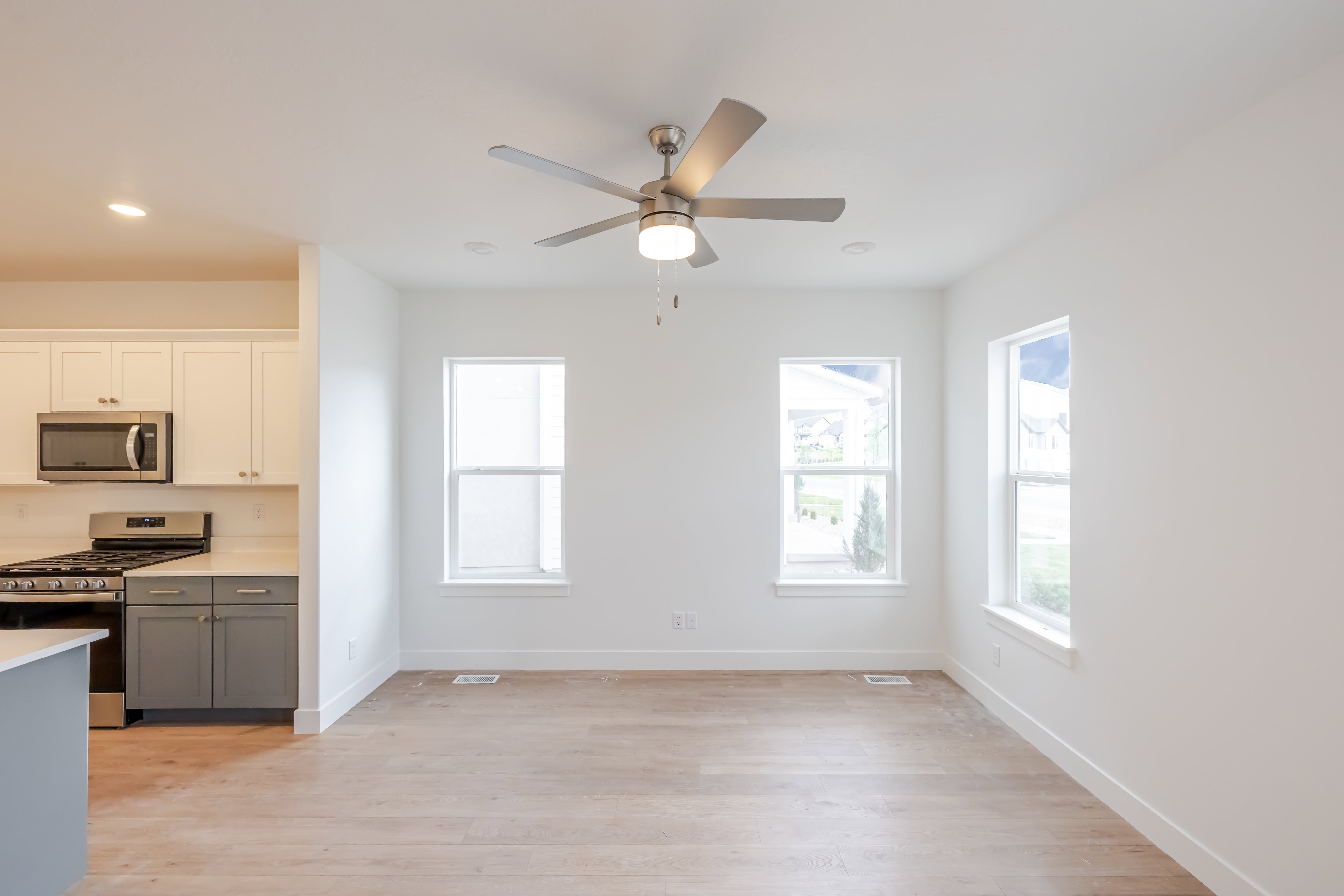 Open-concept living space featuring wood-finish flooring, recessed lighting, and a contemporary ceiling fan
