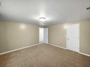 Unfurnished bedroom with carpet flooring and a textured ceiling
