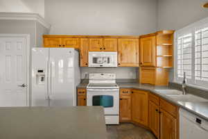 Kitchen with white appliances, open shelves, wood finish cabinetry, and dark countertops