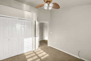 Unfurnished bedroom with a closet, light colored carpet, and a ceiling fan