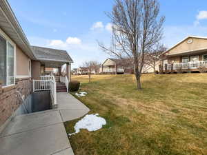 View of grassy yard with a porch and a residential view