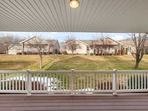 Wooden deck featuring a residential view and a lawn