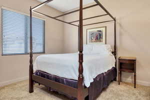 Bedroom with baseboards and light colored carpet