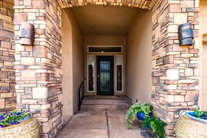 Doorway to property with stone siding and a porch