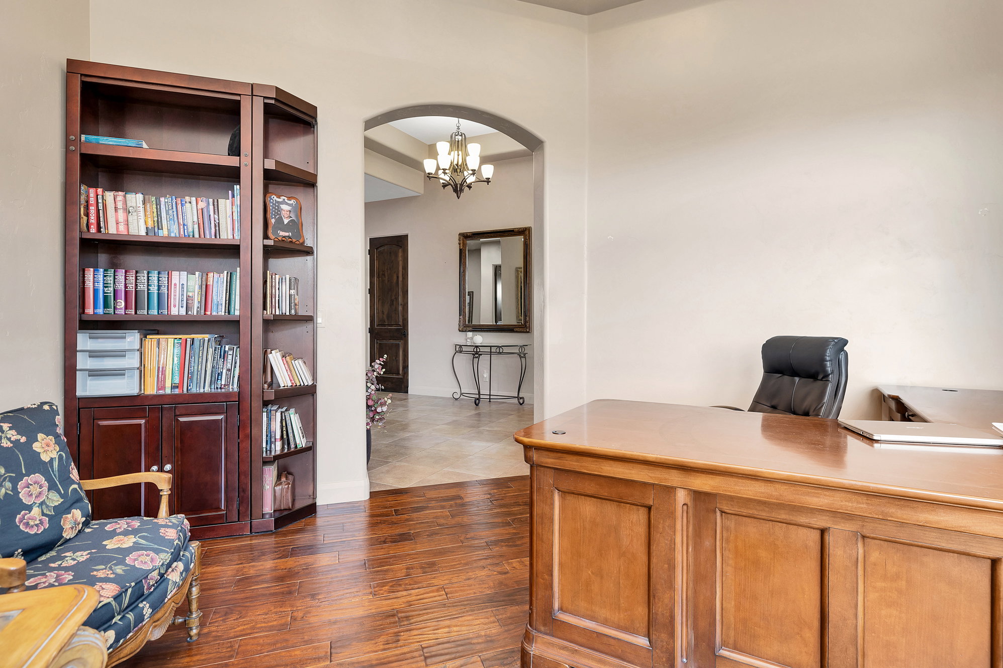 Office space with dark wood-style flooring, arched walkways, and suspended lighting