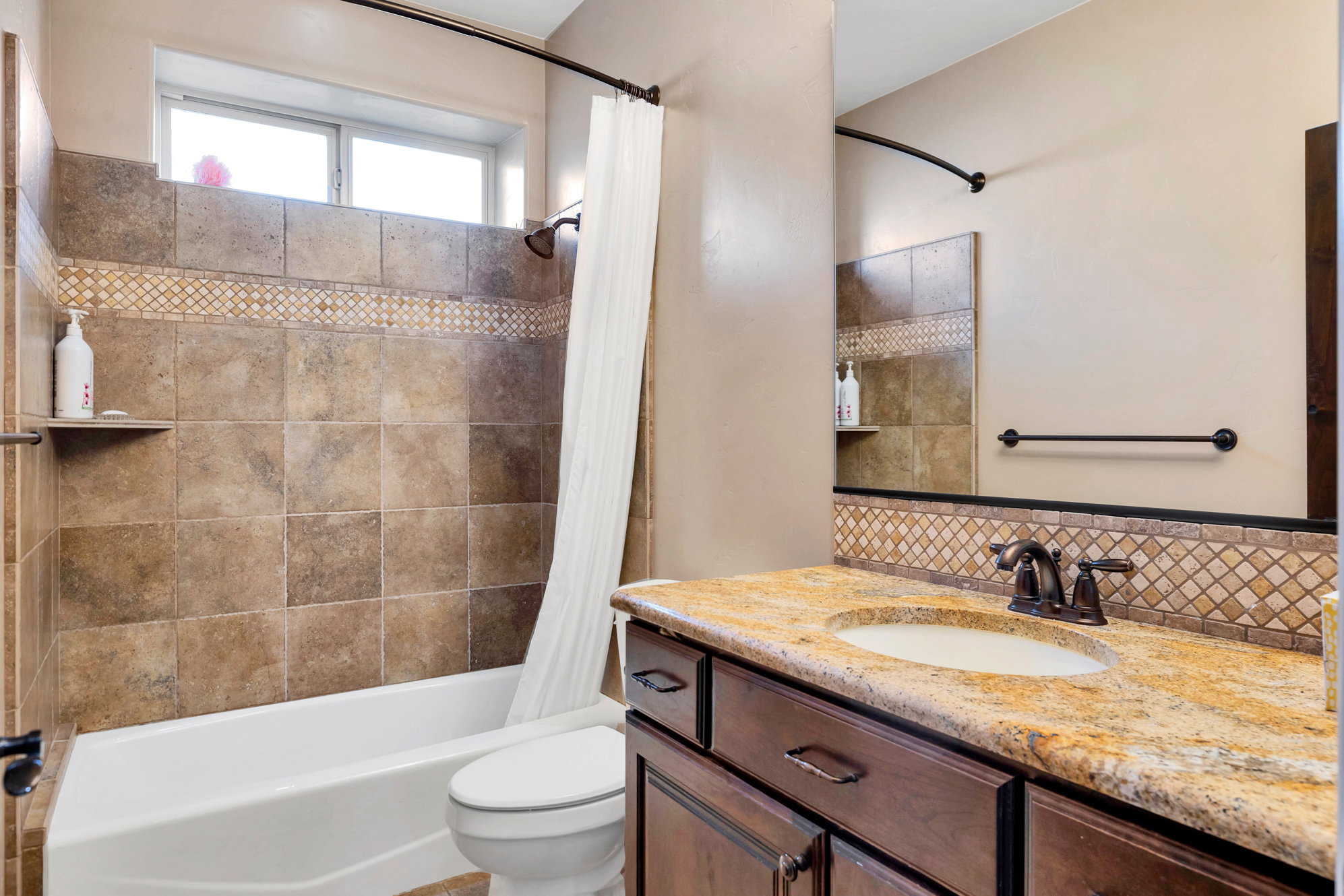 Full bath with vanity, shower / bath combination with curtain, and decorative backsplash