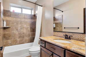 Full bath with vanity, shower / bath combination with curtain, and decorative backsplash