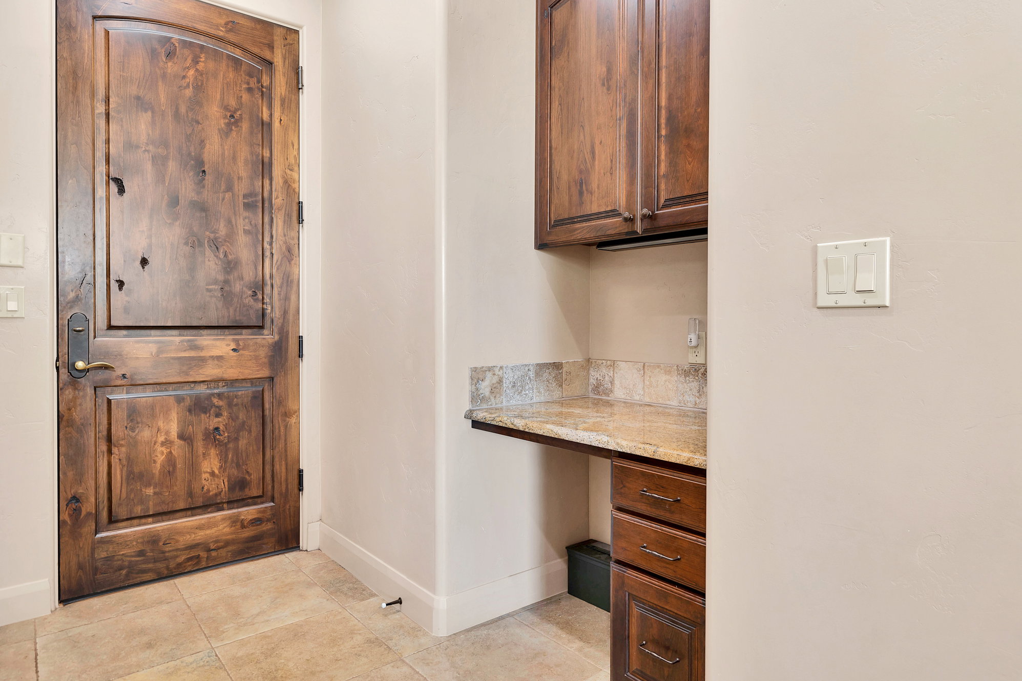 Home office featuring built in study area and light tile patterned floors