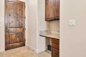Home office featuring built in study area and light tile patterned floors